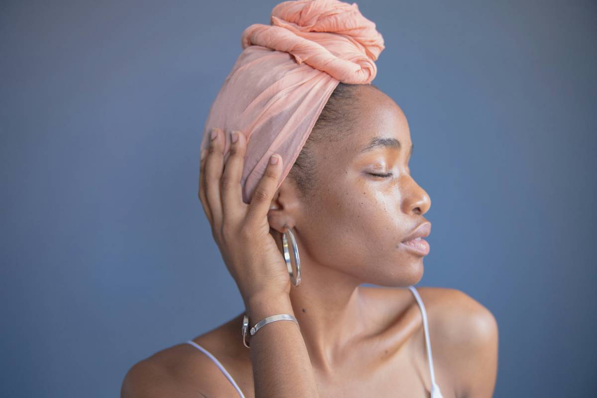 Woman wearing protective hair wraps made of satin scarf for overnight hair care